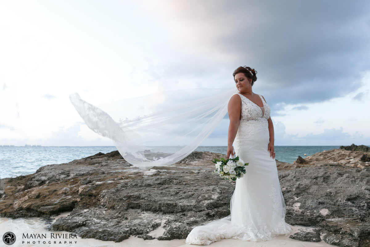 RiuCancunBrideCarlyPosesOnRockWithFloatingVeil