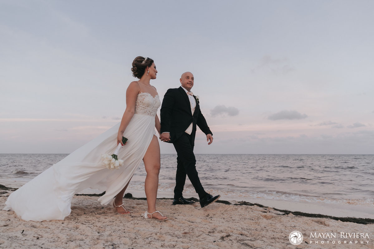 NewlywedsHoldHandsOnBeachwalk