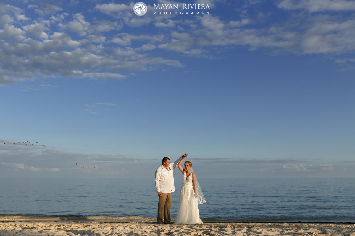 GroomTwirlsSmilingBrideDancingOnBeach