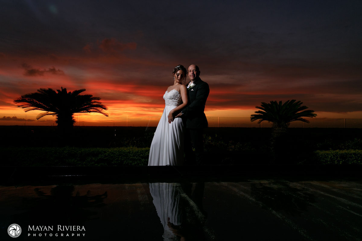 NewlywedsEmbraceShilouettedBySpectacularSunset