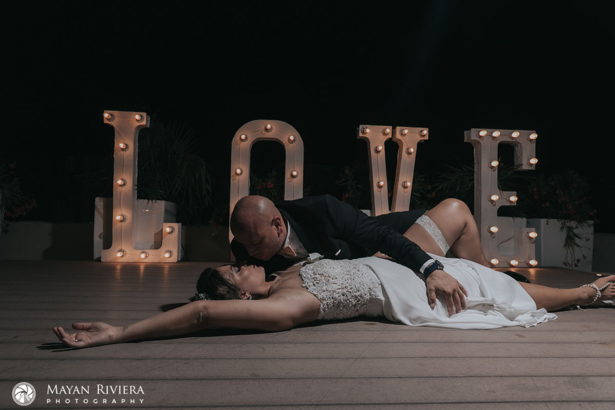 WeddingCoupleReclineInEmbraceByLoveSign