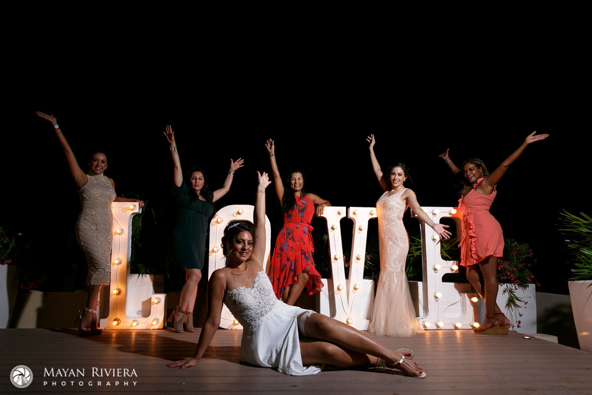 BrideCheersWithBestiesAtLoveSign