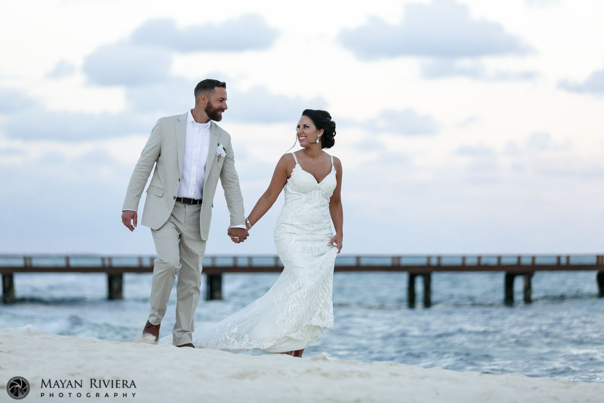 NewlywedOnBeachWalkHoldingHands