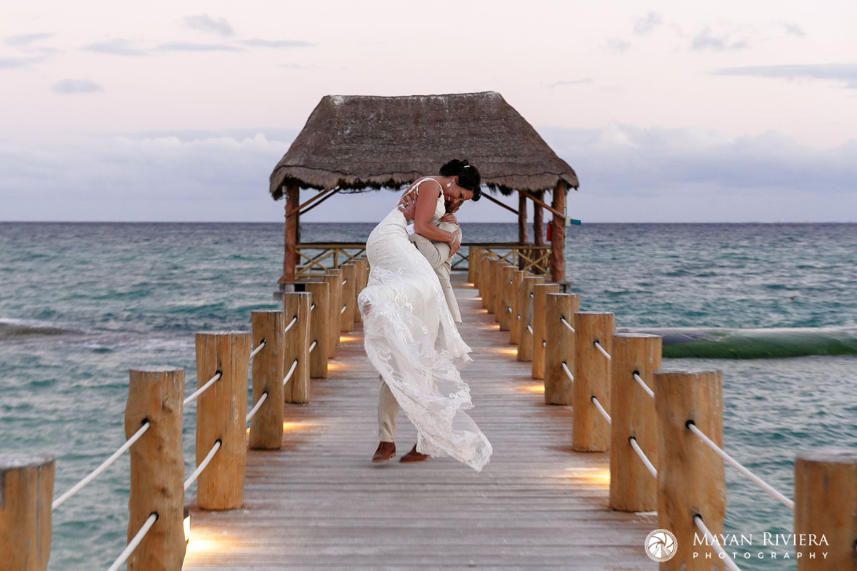BrideJumpsIntoGroomsArmsOnPier