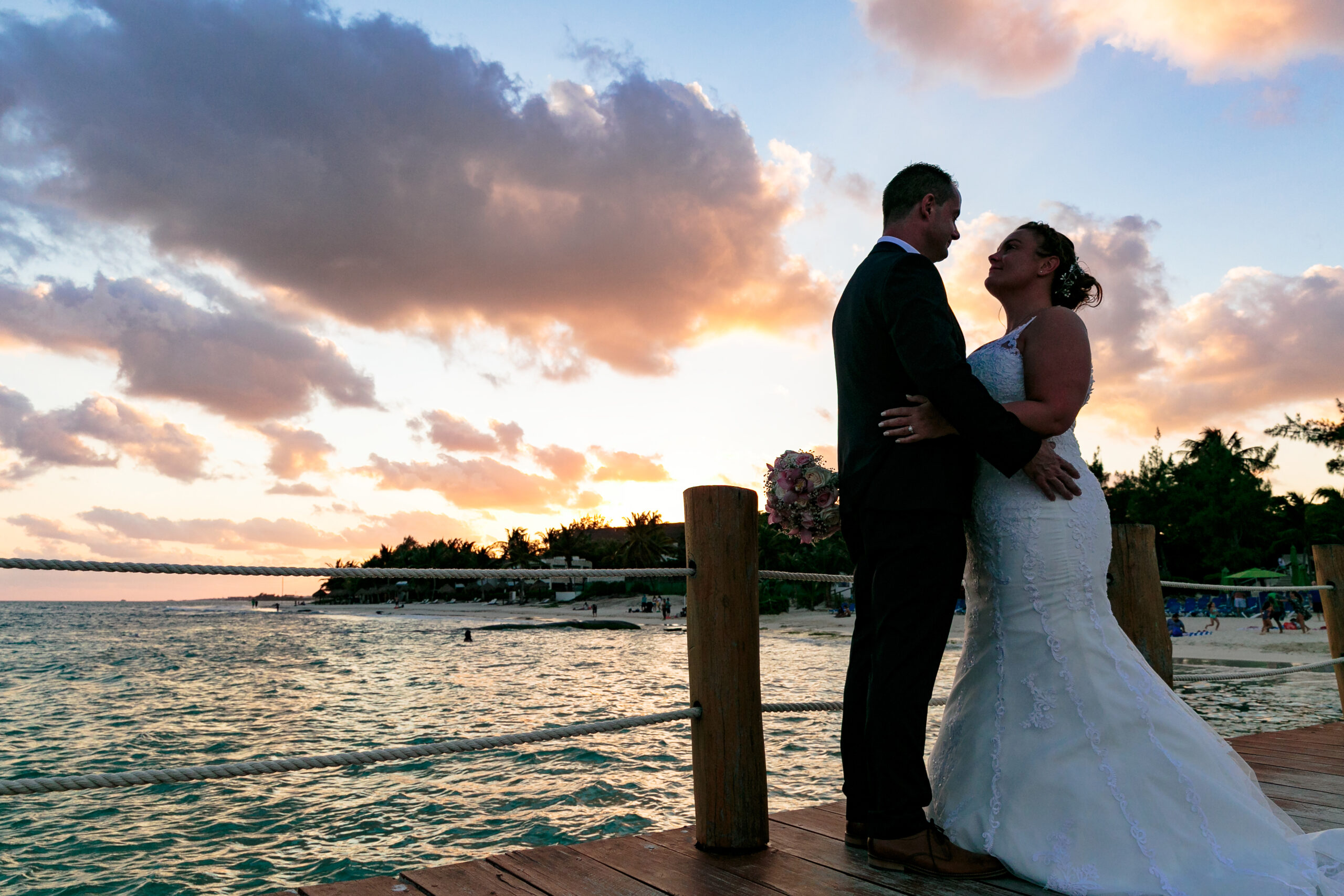 Newlyweds embrace in sunset shilouette