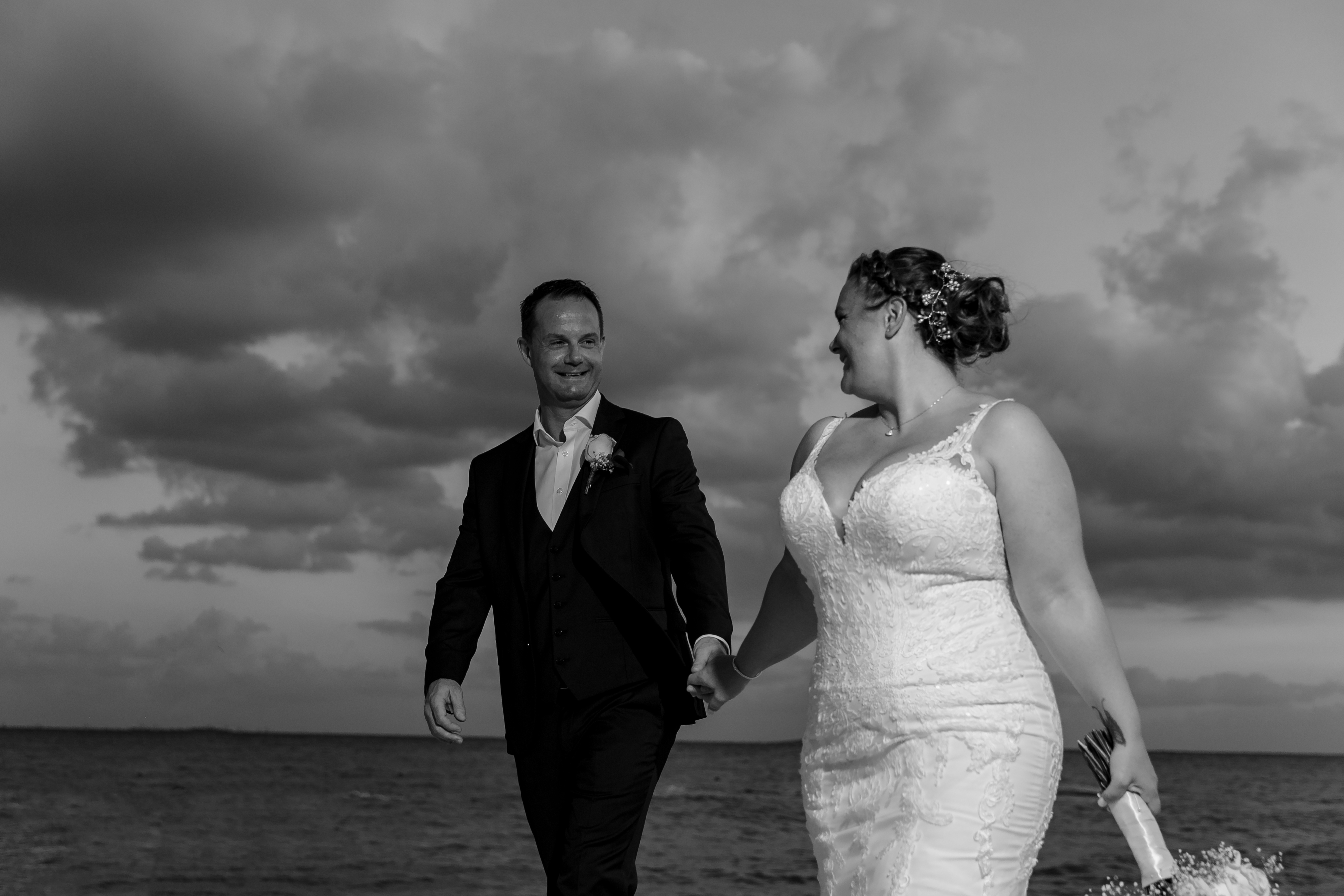 AzulBeachNewlywedsHoldHandsSmiling