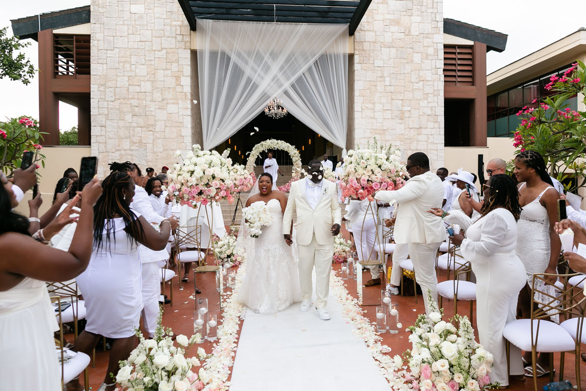 Newlyweds walk out after the ceremony through a shower of petals