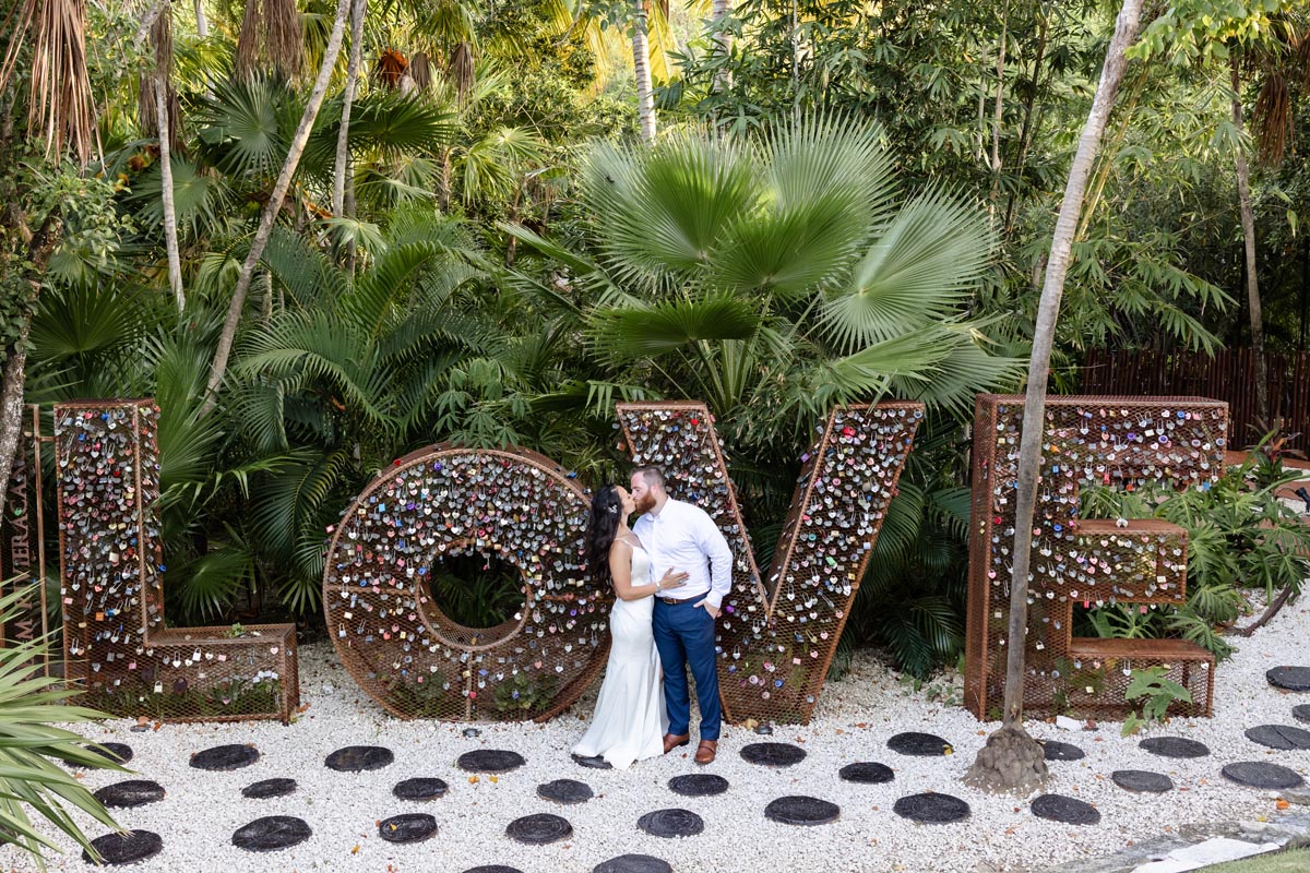 Newlyweds kiss in front of Love Sign