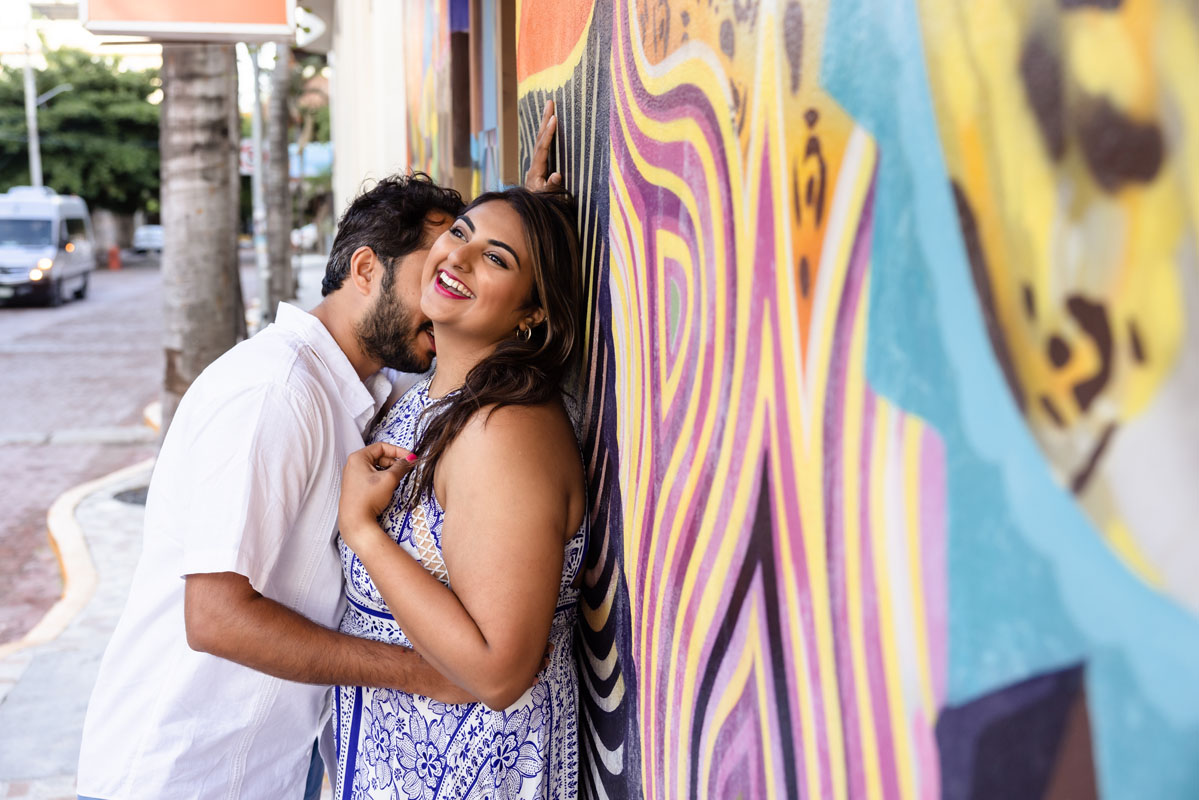 Happy couple embrace by colorful graffiti wall