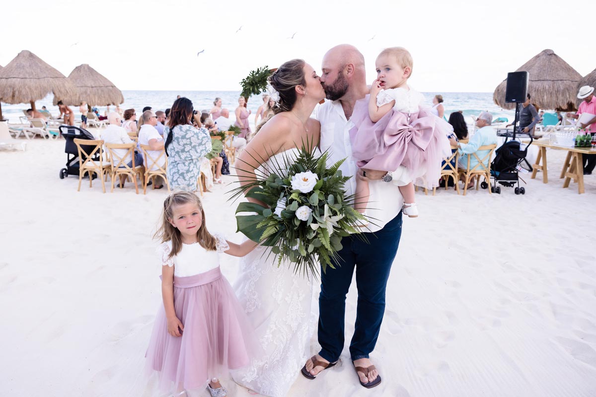 Newlyweds kiss after ceremony with their daughters