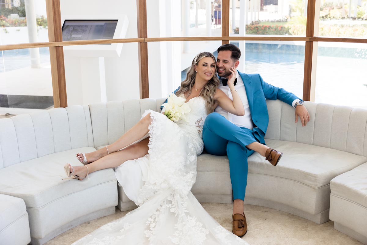 Wedding couple embrace sitting on sofa