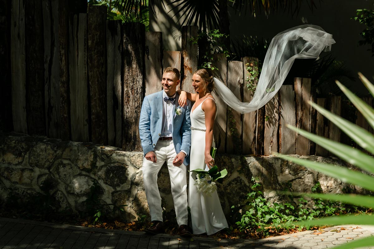 NewlywedsOnGardenPathWithBillowingVeil