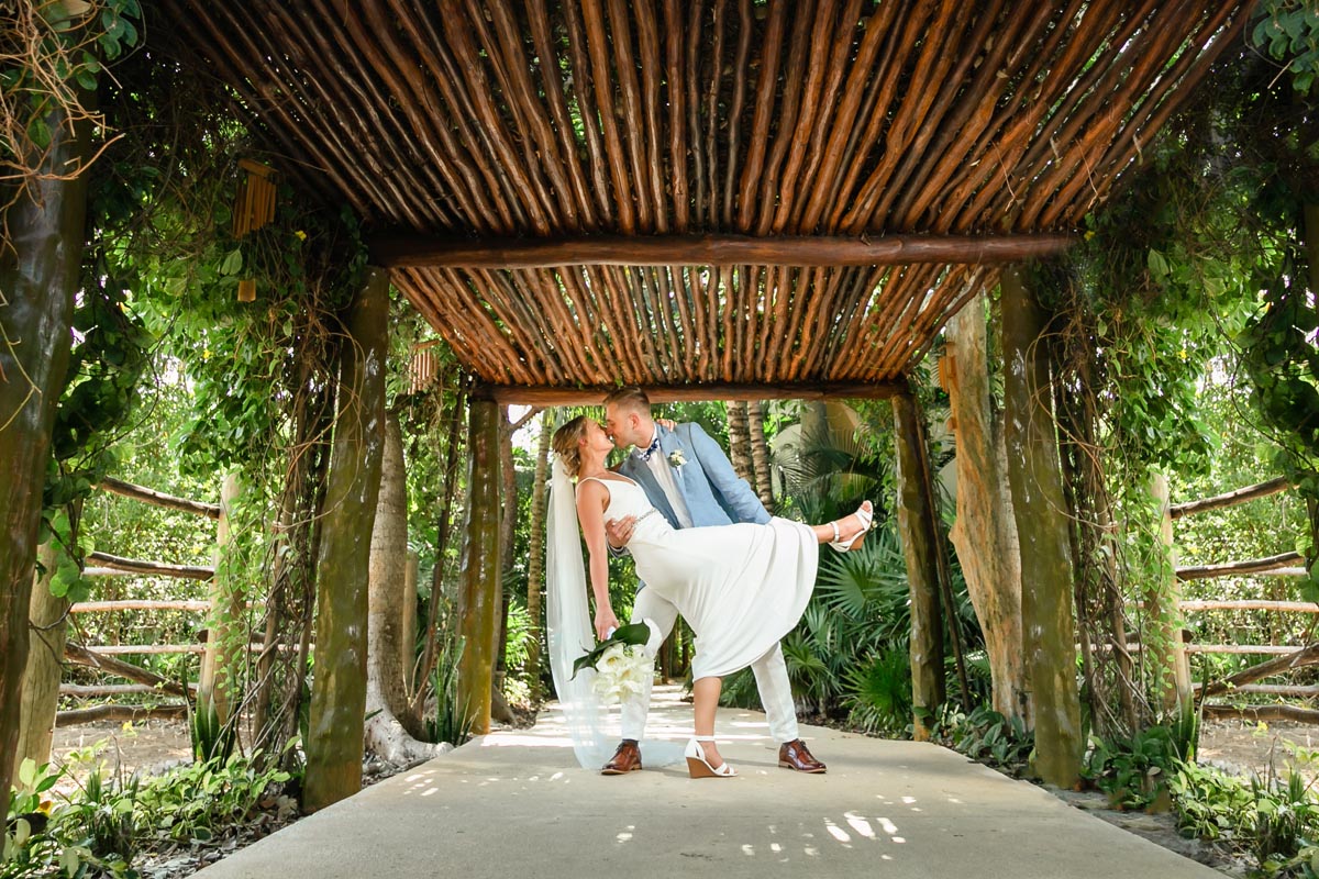 NewlywedsDipOnGardenPathKissing