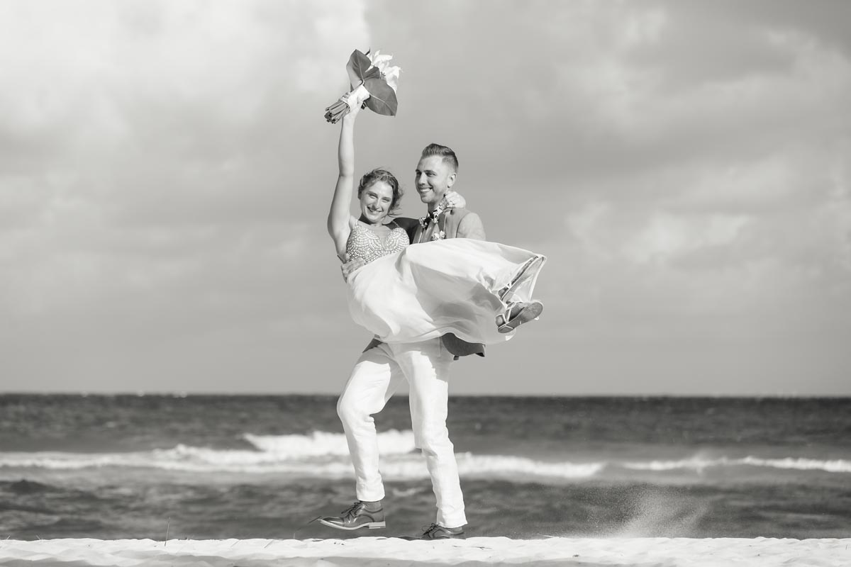 GroomAlexHoldsKelseyInHisArmsCheering