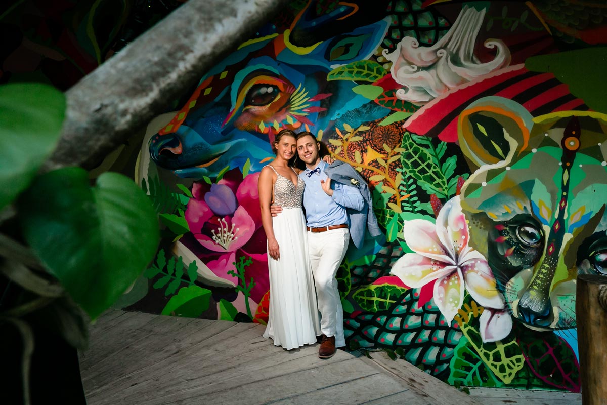 NewlywedsPoseByArtWall