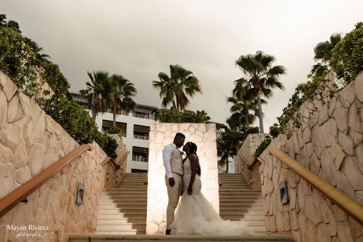 Newlyweds embrace standing on the stone resort steps