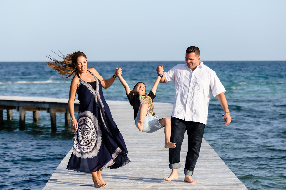 Silvana and hubby swing their laughing son on the pier