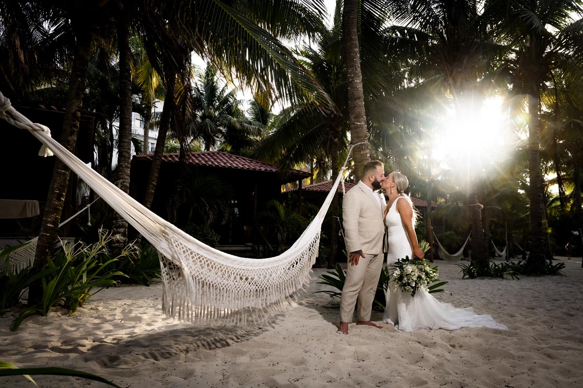 Newlyweds kiss in jungle sunset