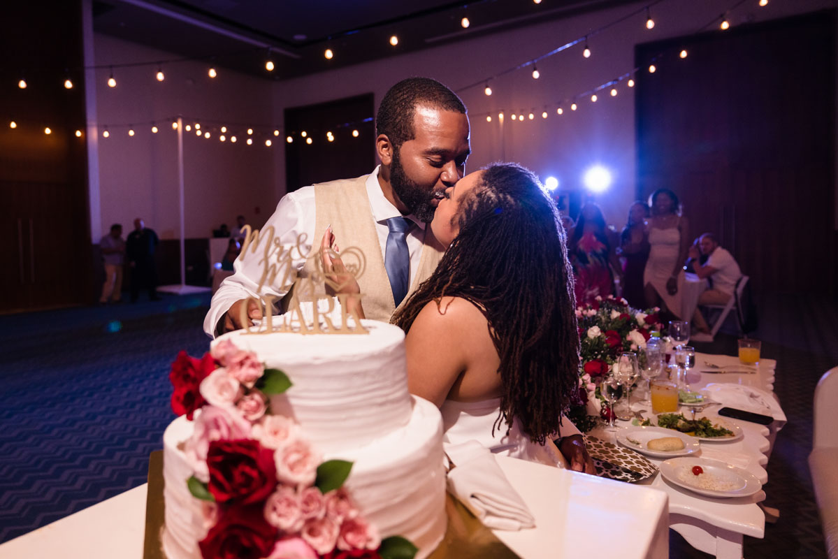 Newlyweds kiss after sampling their wedding cake