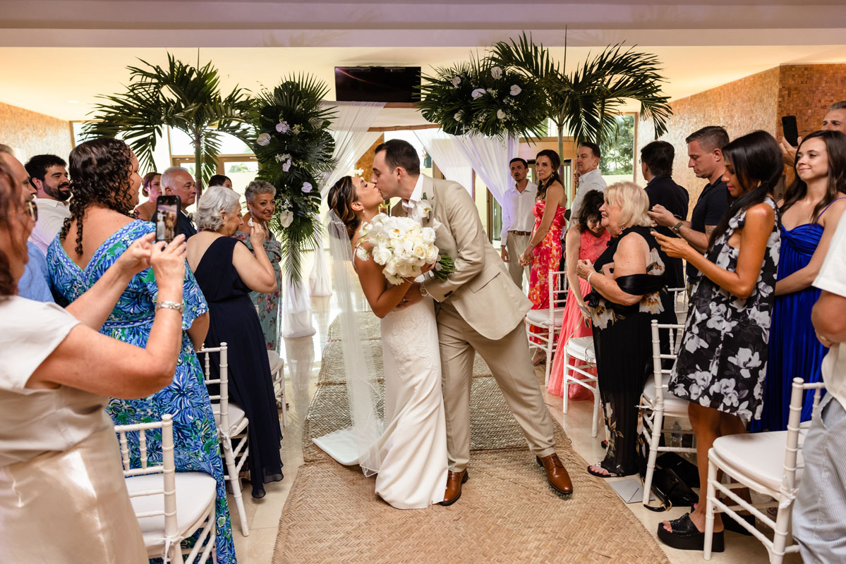 Newlywed groom dips his bride in a kiss after their ceremony