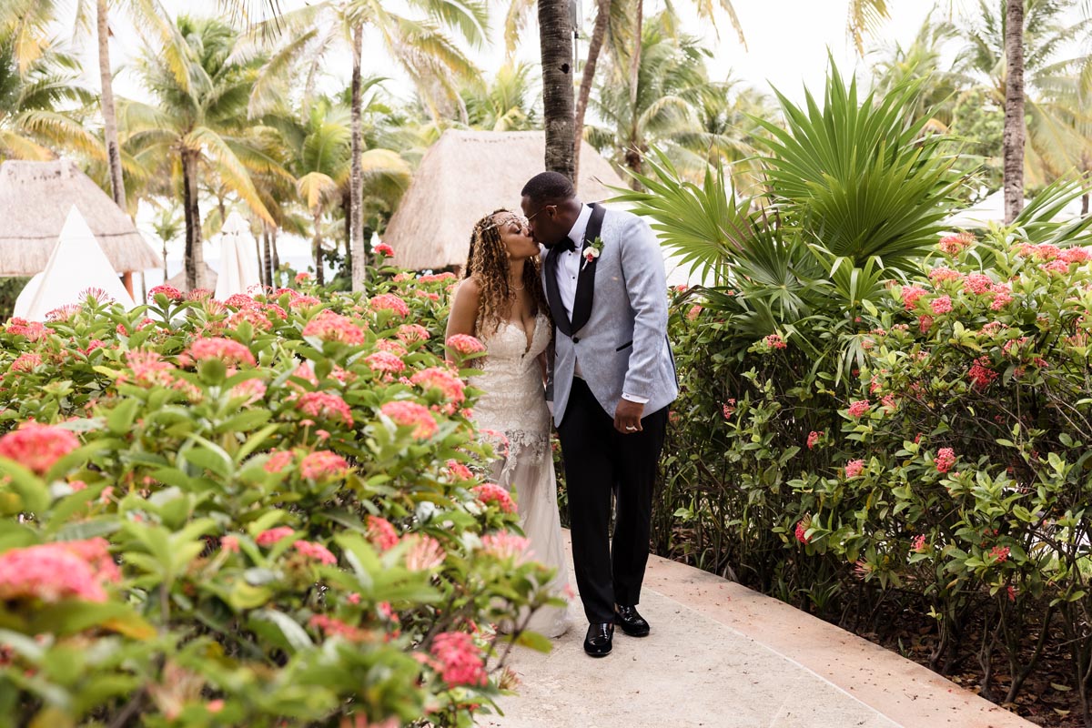 Newlyweds kiss strolling on jungle garden path