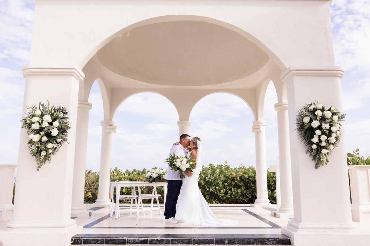 Newlyweds kiss after their ceremony under the beachside dome