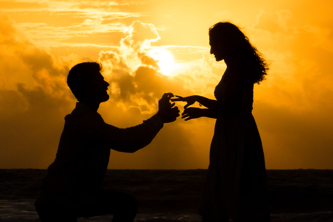 Boyfriend puts ring on finace's finger at sunrise