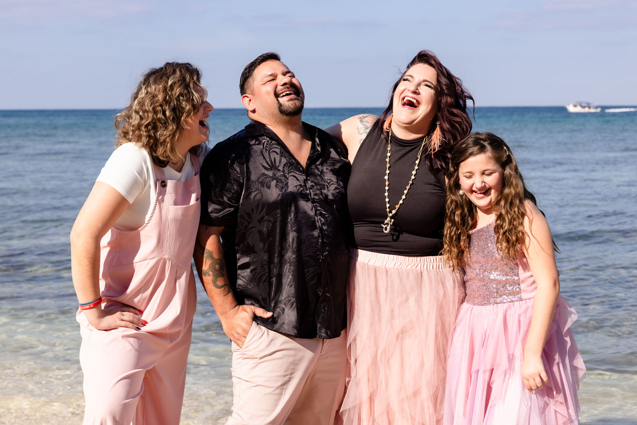 Family laugh together on the beach