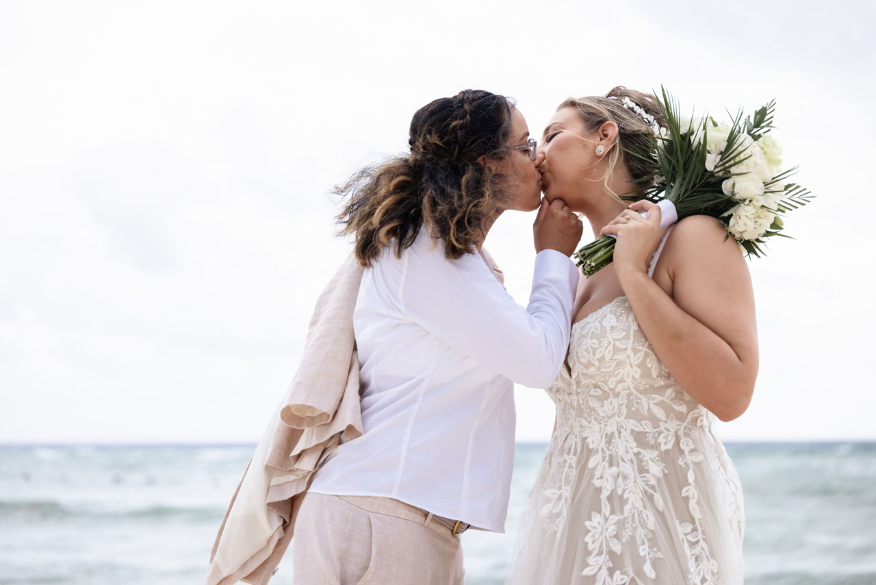 Newlyweds kiss in an embrace on the beach