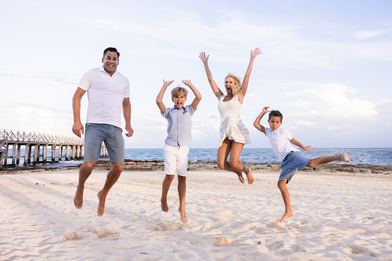 Happy family jumps for joy on the beach